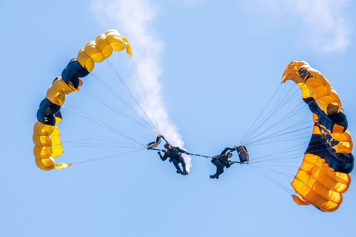 Sgt. 1st Class Ty Kettenhofen and Staff Sgt. Griffin Mueller of the U.S. Army Parachute Team perform an advanced canopy maneuver for a demonstration jump on at Selfridge Air National Guard Base on 10 July, 2022. The jump was part of the Selfridge Open House and Air Show. (U.S. Army photo by Megan Hackett)