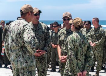 220721-N-VQ947-1031 SAN DIEGO - (July 21, 2022) – San Antonio-class amphibious transport dock ship USS Portland (LPD 27), executive officer, U.S. Navy Cmdr. Jonath Stinnett, center left, and commanding officer , U.S. Navy Capt. Matthew Thomas, center right, listen as U.S. Navy
