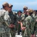 220721-N-VQ947-1031 SAN DIEGO - (July 21, 2022) – San Antonio-class amphibious transport dock ship USS Portland (LPD 27), executive officer, U.S. Navy Cmdr. Jonath Stinnett, center left, and commanding officer , U.S. Navy Capt. Matthew Thomas, center right, listen as U.S. Navy