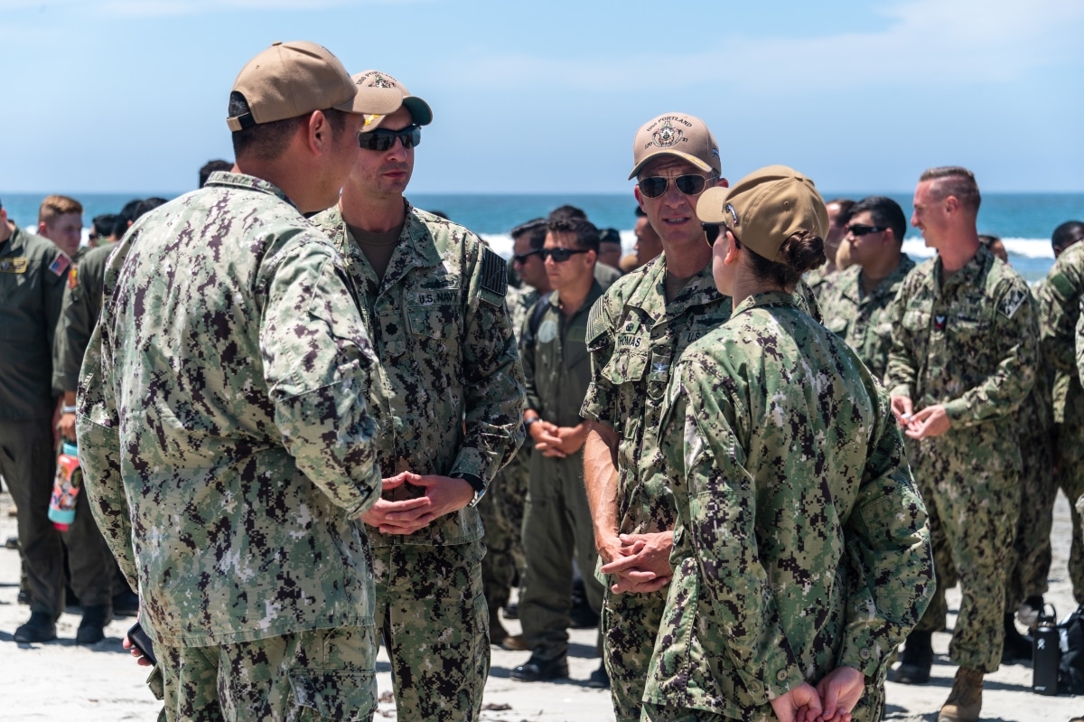 220721-N-VQ947-1031 SAN DIEGO - (July 21, 2022) – San Antonio-class amphibious transport dock ship USS Portland (LPD 27), executive officer, U.S. Navy Cmdr. Jonath Stinnett, center left, and commanding officer , U.S. Navy Capt. Matthew Thomas, center right, listen as U.S. Navy