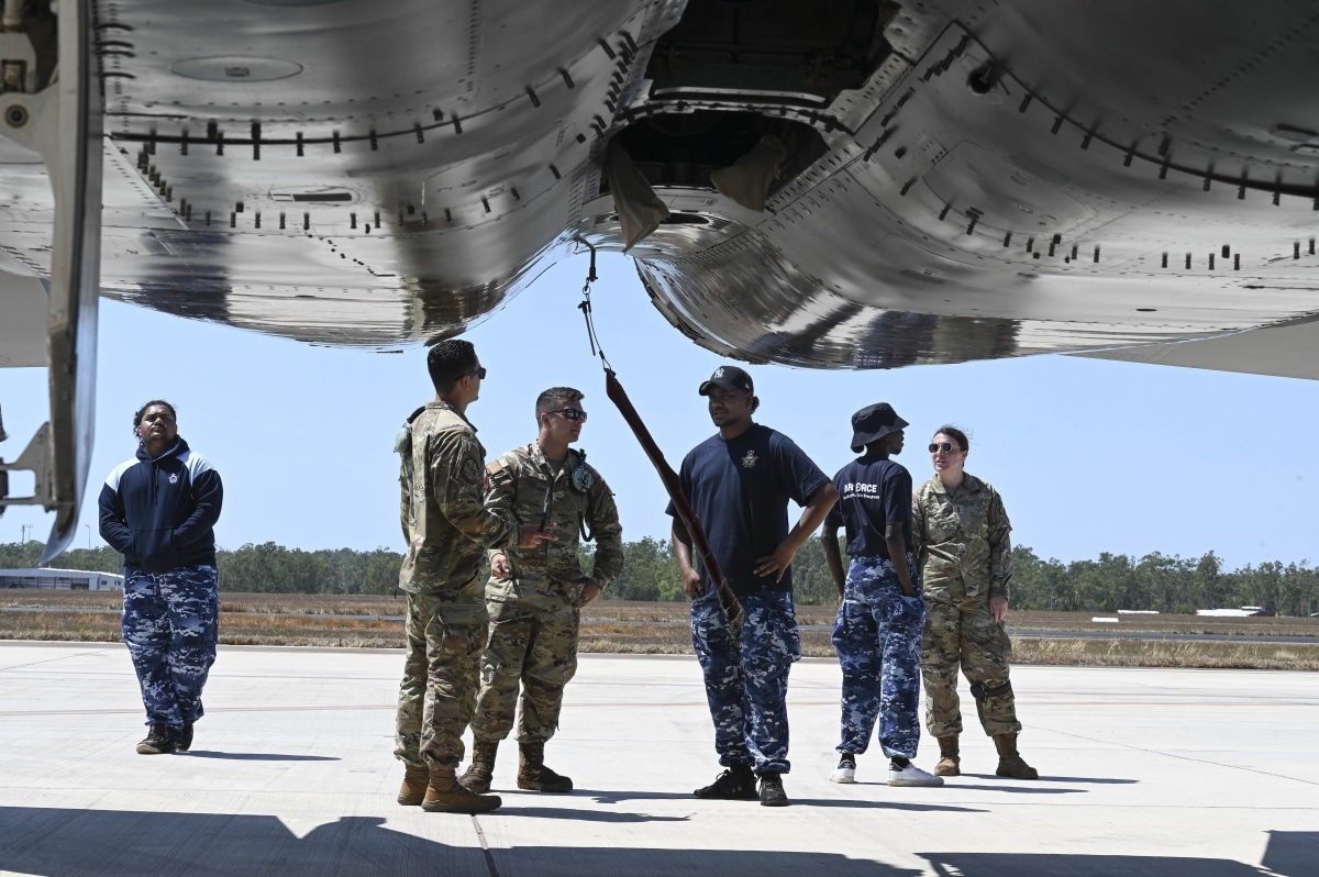 U.S. Airmen from the 67th Aircraft Maintenance Unit speak to Royal Australian Air Force Indigenous Youth Program members during their visit to RAAF Base Darwin