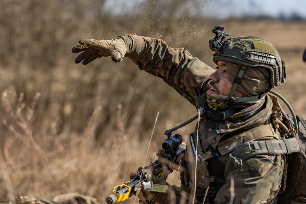 A Polish soldier assigned to the 15th Mechanized Infantry Brigade, and a member of NATO eFP Battle Group Poland, throws a training grenade during the British Army Potential Noncommissioned Officer Course simulated training exercise in Bemowo Piskie, Poland