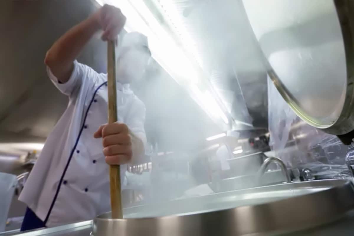 Abstract, blurry, bokeh background, image for the background. A cook on a ship preparing food in a large cauldron