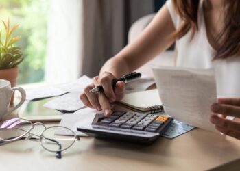 Stressed young woman calculating monthly home expenses, tax, bank account balance and credit card bills payment, Income is not enough for expenses.