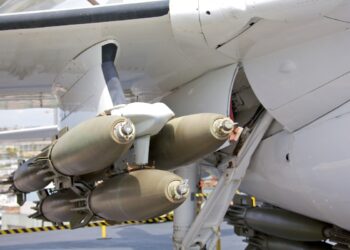 A cluster of bombs mounted under the wing of a modern fighter aircraft