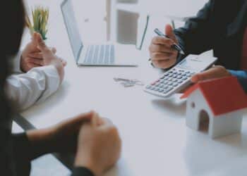 lawyer insurance broker consulting giving legal advice to couple customer about buying renting house. financial advisor with mortgage loan investment contract. realtor selling real estate property