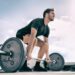 Gym fitness weightlifting deadlift man bodybuilding powerlifting at outdoor summer health club. Bodybuilder doing barbell weight lifting training workout with heavy bar.