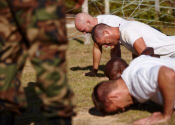 Youve gotta push through the pain. Shot of a group of men doing push-ups at a military bootcamp.