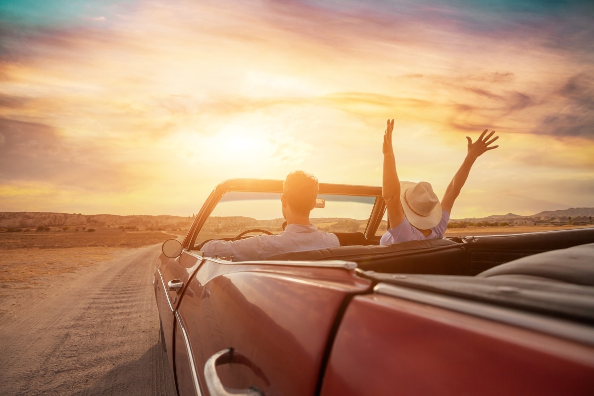happy people traveling in classic vintage car, couple during honeymoon