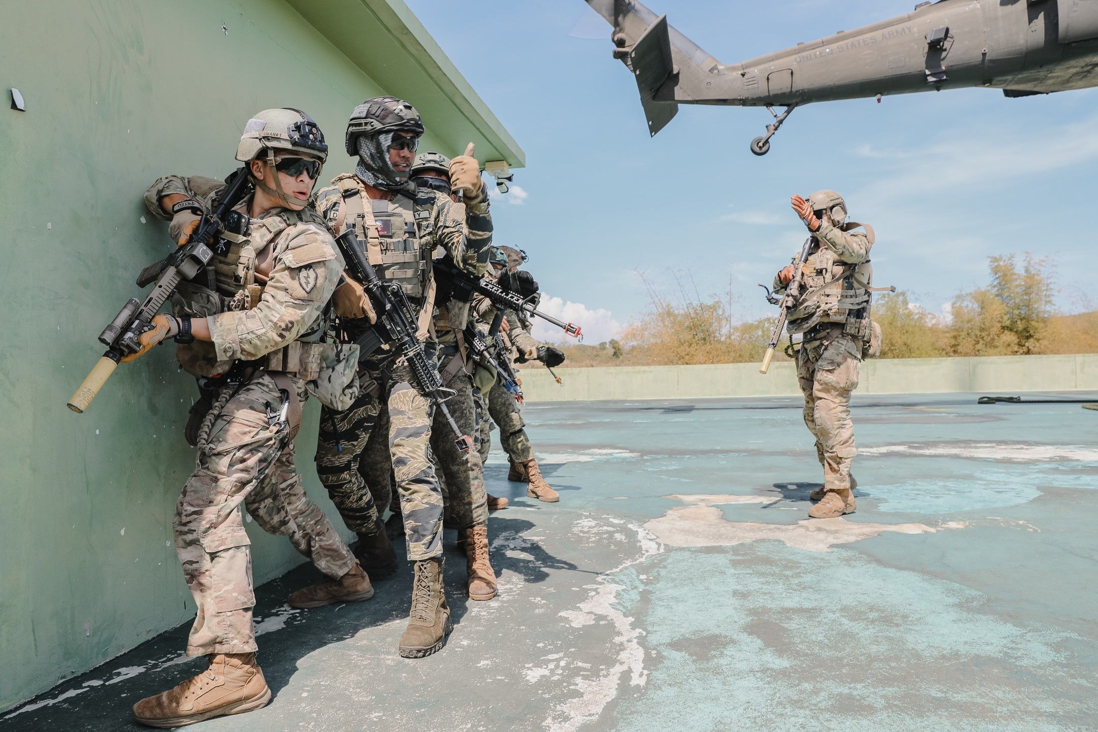 Elite members of the Philippine Army (PA) Light Reaction Regiment (LRR), Filipino Scout Ranger Regiment (FSRR), PA Special Forces, US Army 75th Ranger Regiment, US Special Forces (SF), and the 1-27IN "Wolfhounds" conduct a fast rope insertion (FRIES) onto a rooftop, before entering and clearing the building below to rescue and extract two hostages.