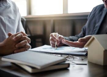 Real estate broker agent being analysis and making the decision a home estate loan to customer to signing contract documents for realty purchase, Bank employees recommend mortgage loan approval.