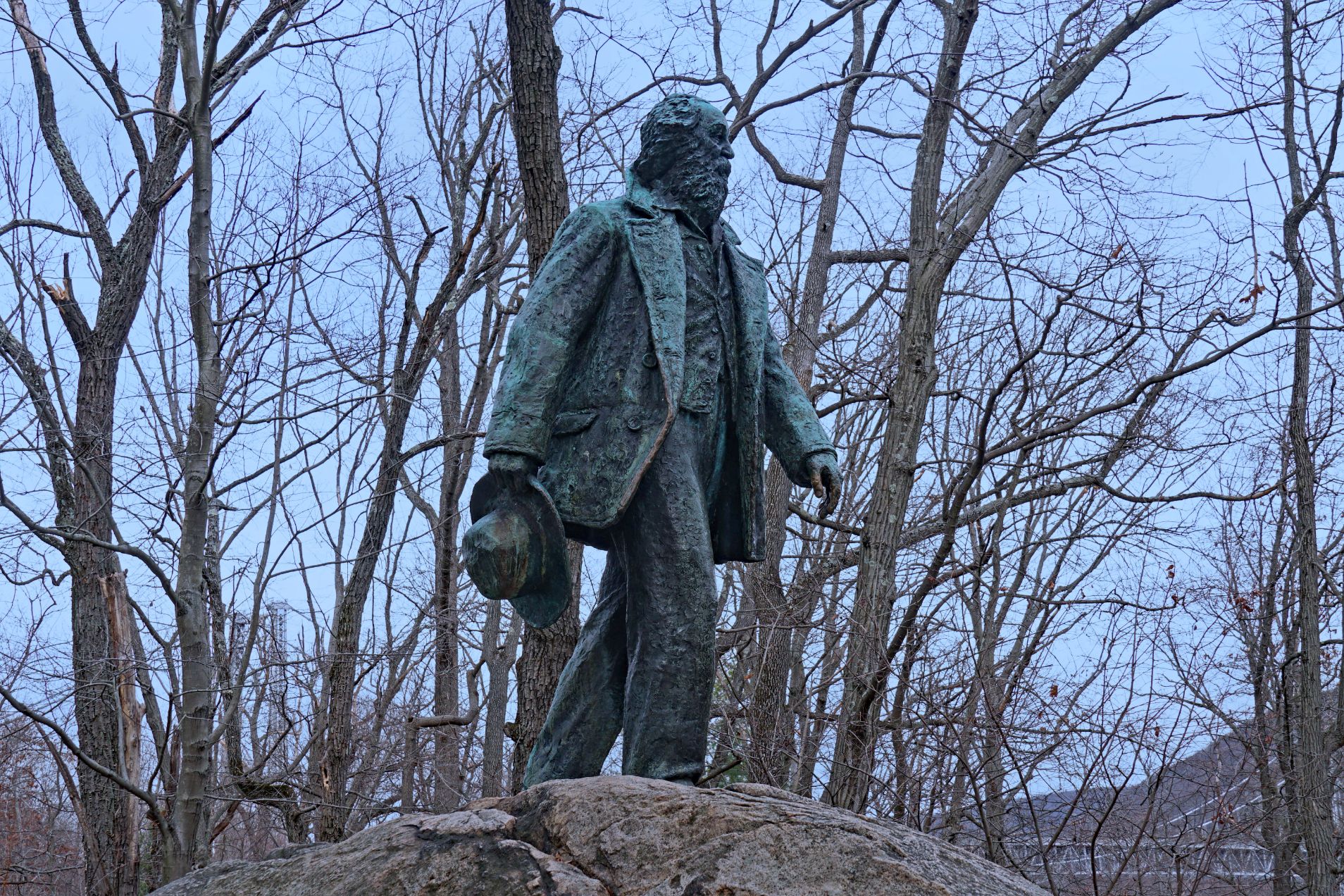 New York State - December 30, 2020: Lifelike bronze statue of great American poet Walt Whitman atop a boulder on the AppalachianTrail in Bear Mountain State Park.