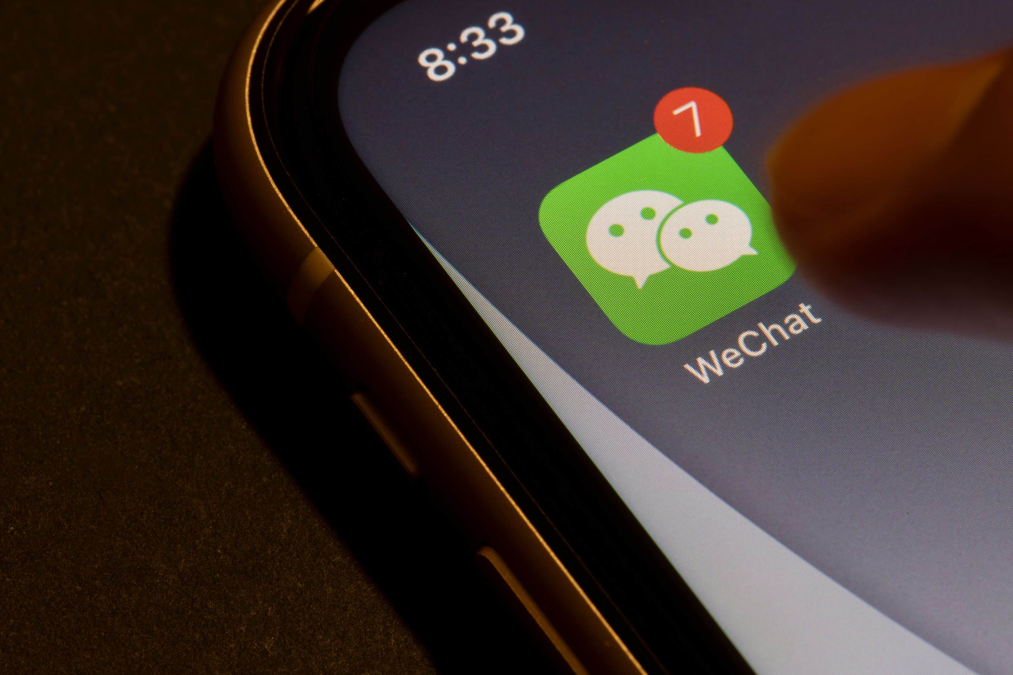 Portland, OR, USA - Aug 19, 2021: Finger touching WeChat app icon with unread message badge on an iPhone. Tencent's WeChat is a Chinese multi-purpose messaging, social media and mobile payment app.
