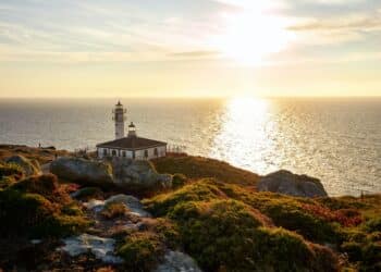 Tourinan Lighthouse in Muxia, Galician coast, Spain. Twice a year, at the beginning of spring and the end of summer, Cape Touriñan becomes the last shadow for the sunset in continental Europe.