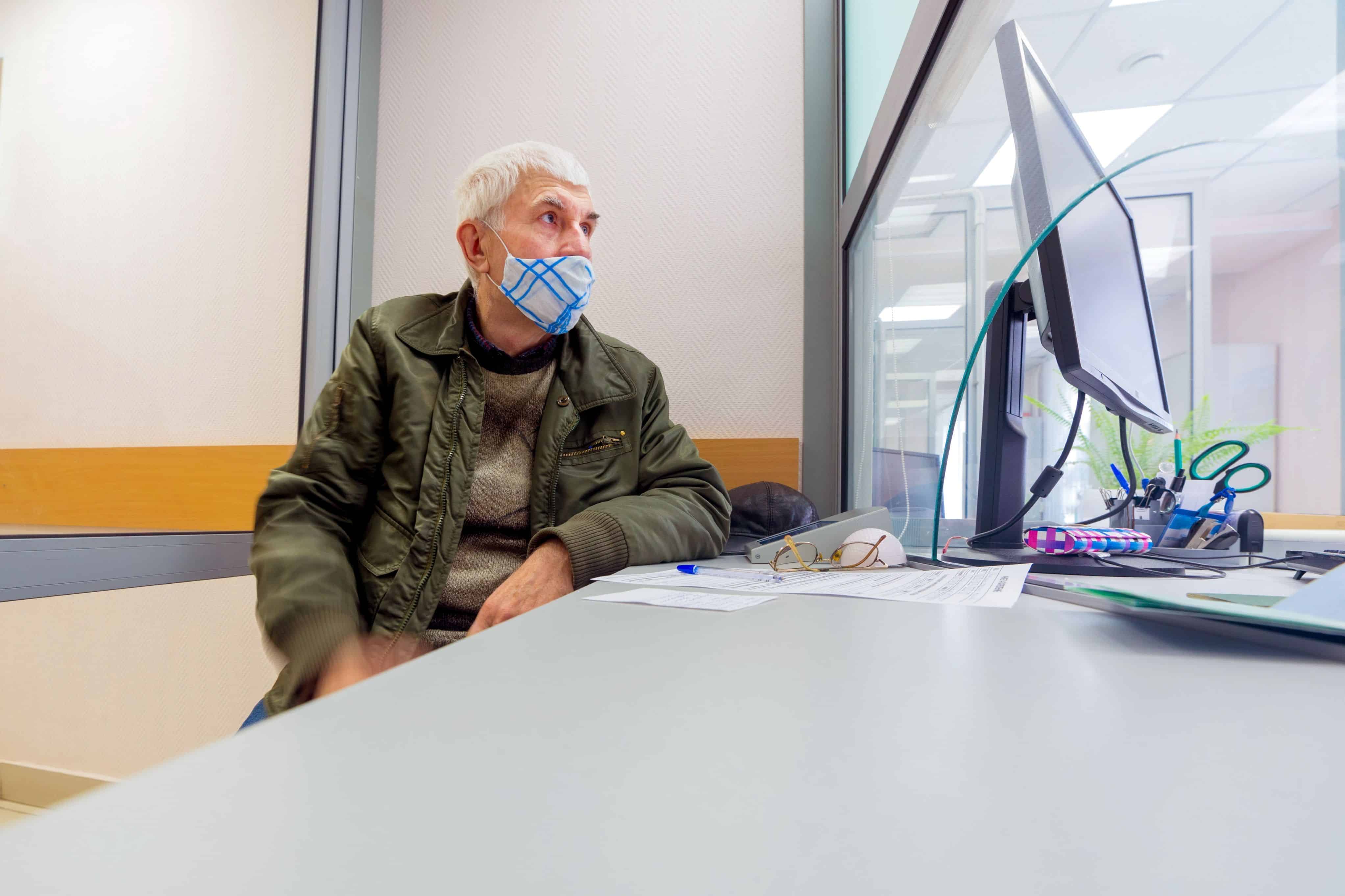 An elderly man writes an application for a pension at the Russian Pension Fund.