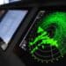 Radar screen with green display indication on a captains bridge of modern ship