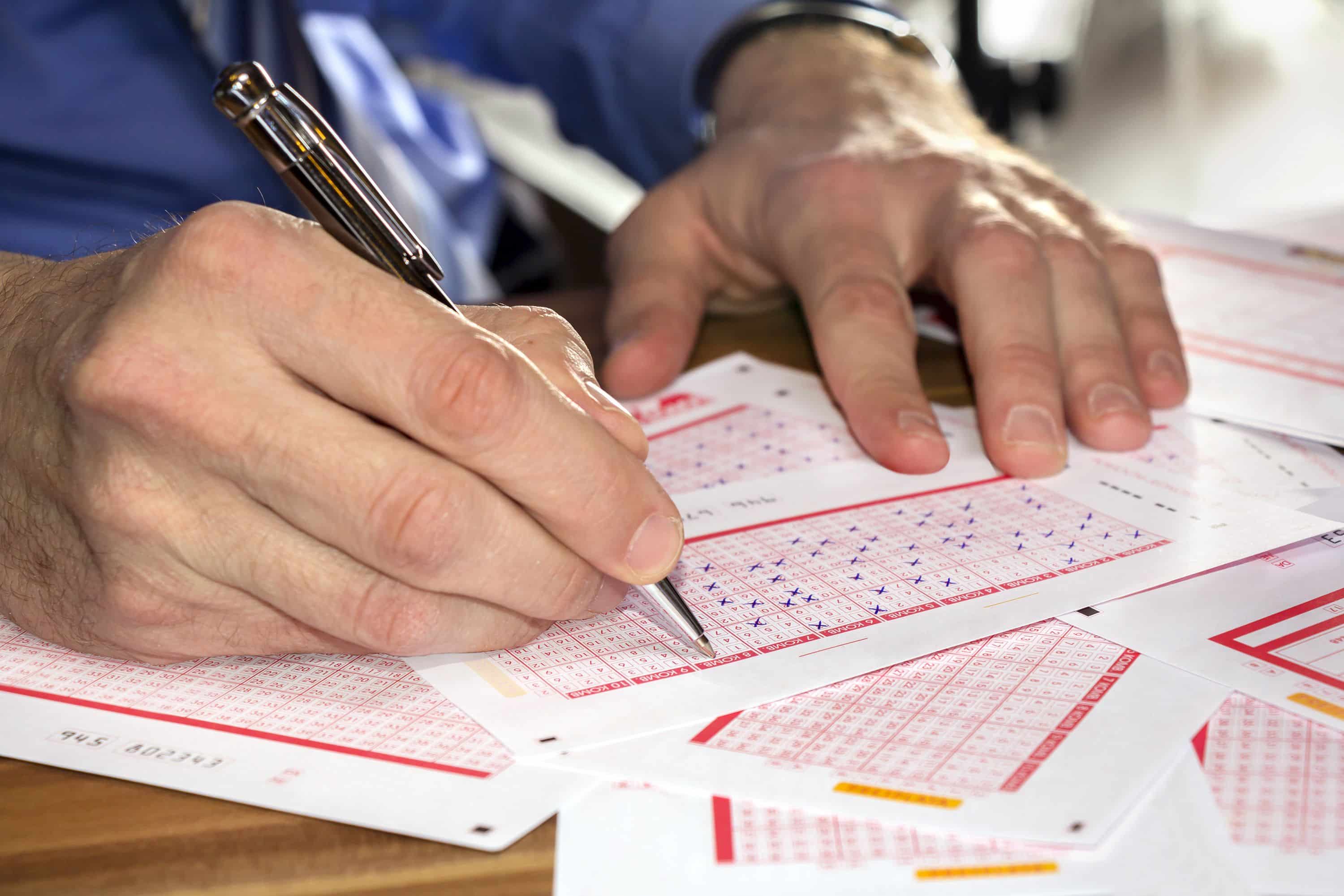 Man Marking on lottery ticket with a pen