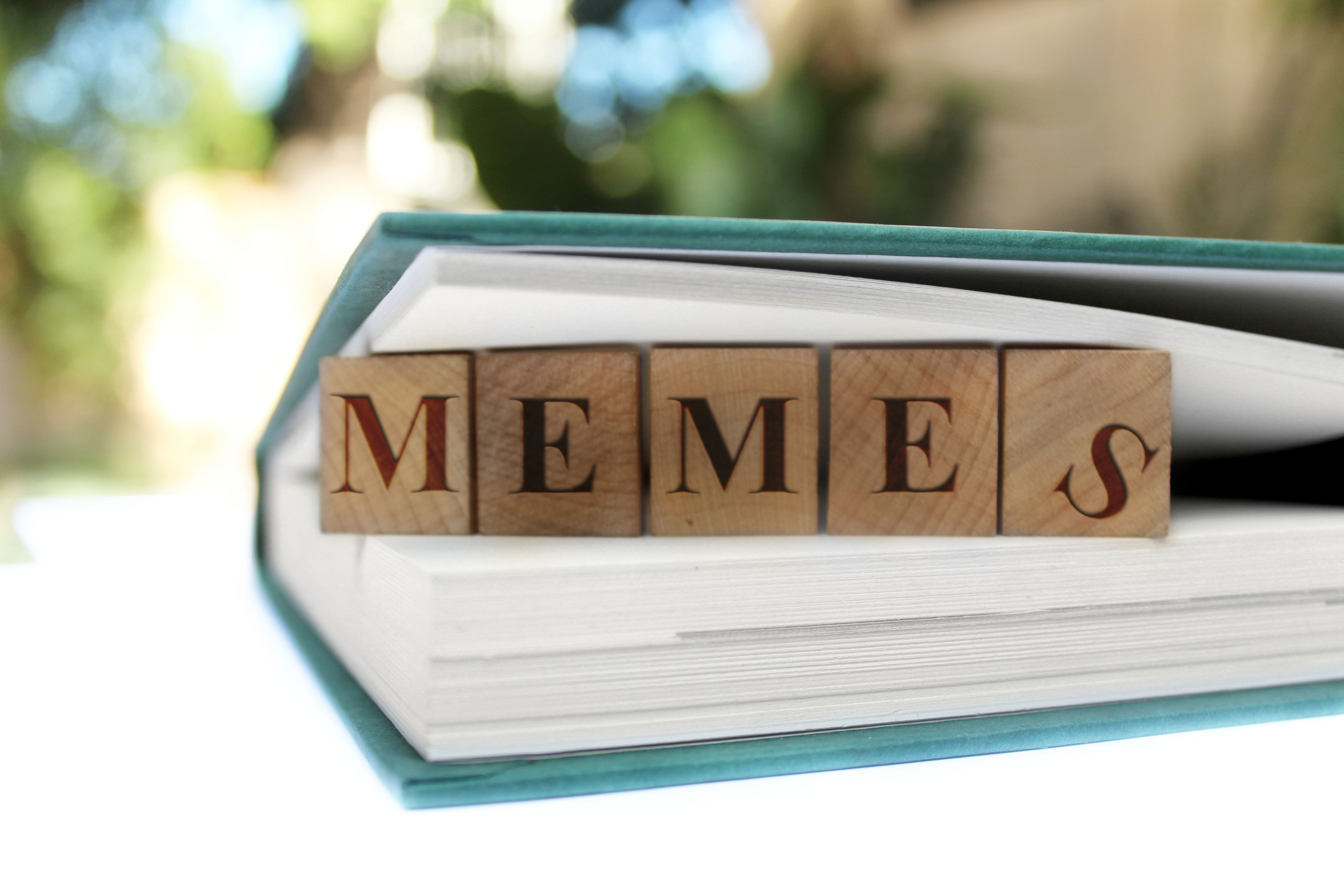 Read Between the lines. Concept Memes Research and learn. Wooden tiles between pages of a book. Stock photo. White space for your own info.