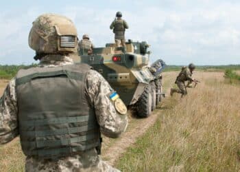 A Ukrainian Observer Coach Trainer looks on as soldiers from Ukraine’s 1st Battalion, 95th Separate Airmobile Brigade dismount their BTR-3 armored personnel carrier during combined mounted and dismounted movement techniques training at the Yavoriv Combat Training Center on the International Peacekeeping and Security Center near Yavoriv, Ukraine on Aug. 21.