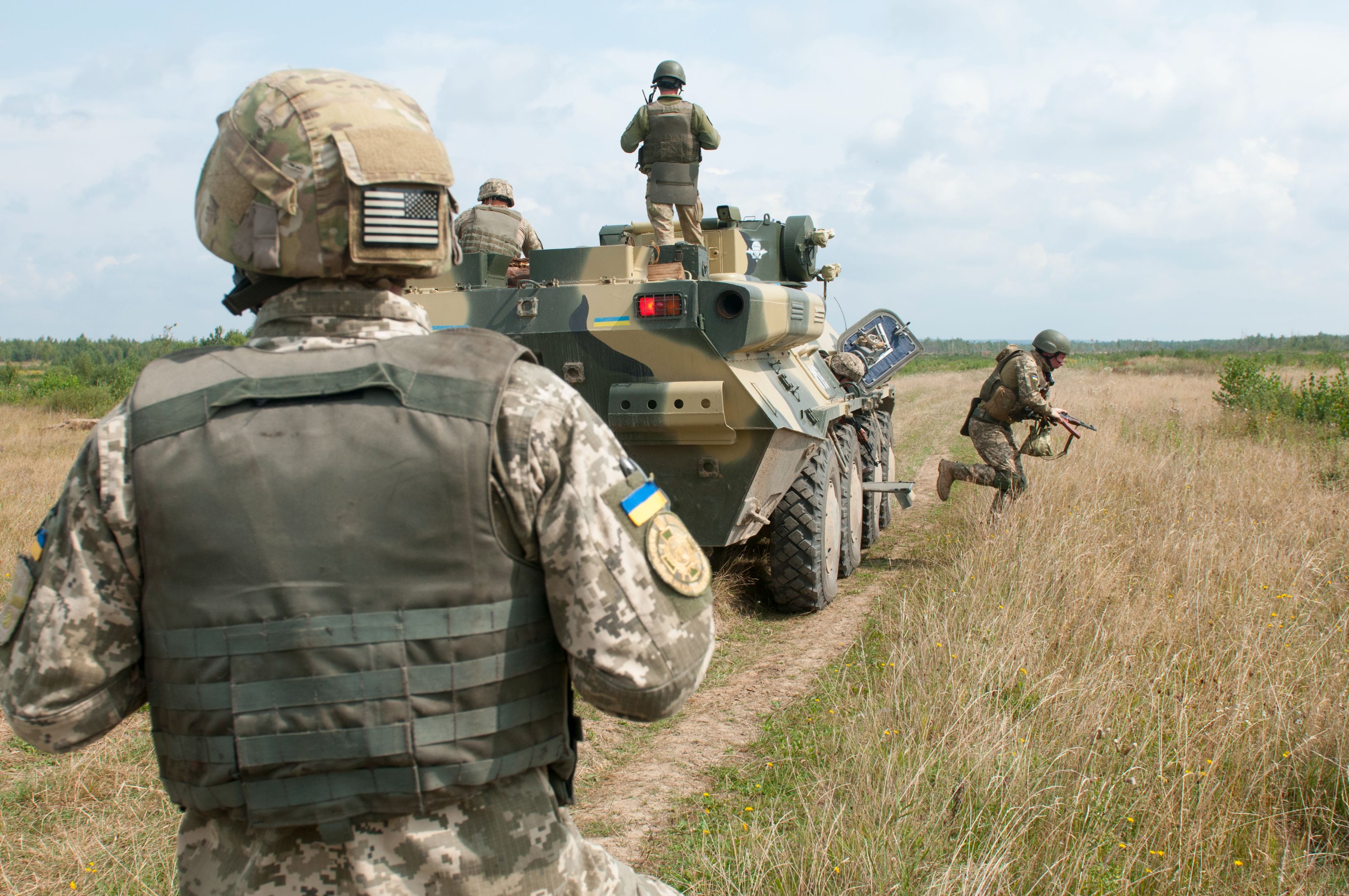A Ukrainian Observer Coach Trainer looks on as soldiers from Ukraine’s 1st Battalion, 95th Separate Airmobile Brigade dismount their BTR-3 armored personnel carrier during combined mounted and dismounted movement techniques training at the Yavoriv Combat Training Center on the International Peacekeeping and Security Center near Yavoriv, Ukraine on Aug. 21.