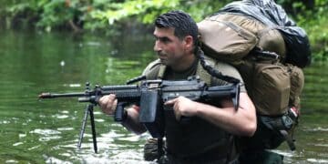 A Special Forces candidate assigned to the U.S. Army John F. Kennedy Special Warfare Center and School crosses a water obstacle during the final phase of field training known as Robin Sage in central North Carolina, July 9, 2019. Robin Sage is the culmination exercise and has been the litmus test for Soldiers striving to earn the Green Beret for more than 40 years. (U.S. Army photo illustration by K. Kassens)