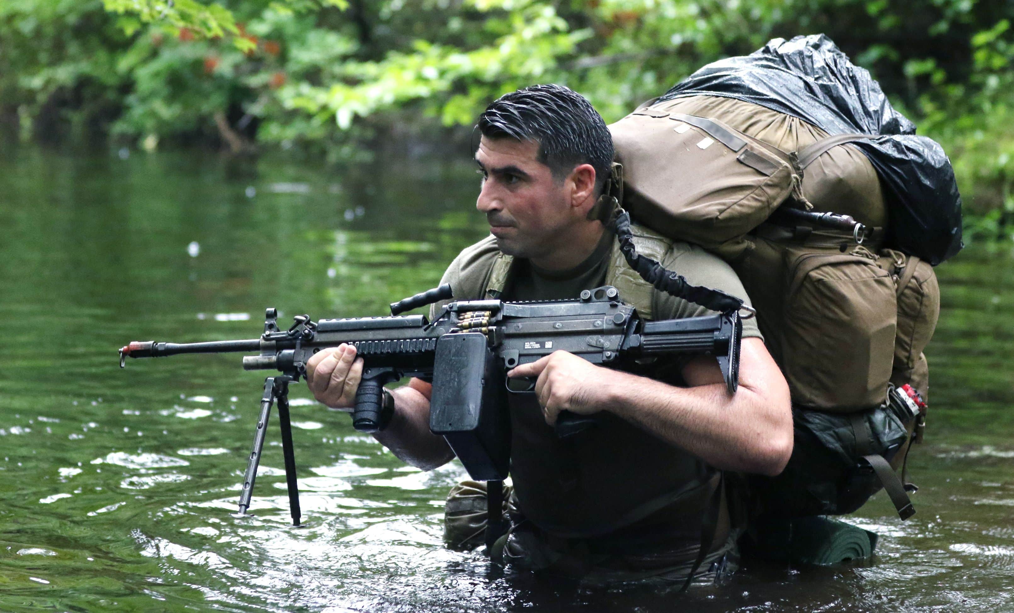 A Special Forces candidate assigned to the U.S. Army John F. Kennedy Special Warfare Center and School crosses a water obstacle during the final phase of field training known as Robin Sage in central North Carolina, July 9, 2019. Robin Sage is the culmination exercise and has been the litmus test for Soldiers striving to earn the Green Beret for more than 40 years. (U.S. Army photo illustration by K. Kassens)