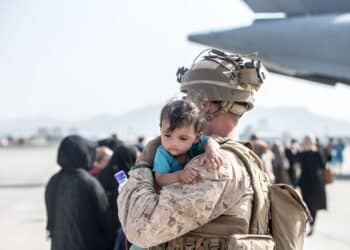 210821-M-GQ845-1048 HAMID KARZAI INTERNATIONAL AIRPORT, Afghanistan (August 21, 2021) A Marine with Special Purpose Marine Air-Ground Task Force-Crisis Response-Central Command (SPMAGTF-CR-CC) calms an infant during an evacuation at Hamid Karzai International Airport, Kabul, Afghanistan, Aug. 21. U.S.