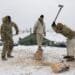 U.S. Army infantrymen with B Company, 1st Battalion, 5th Infantry Regiment, 1st infantry Brigade Combat Team, 11th Airborne Division, chop fire wood during a lull in fighting while acting as opposition forces for Joint Pacific Multinational Readiness Center-Alaska 23-02 at Yukon Training Area