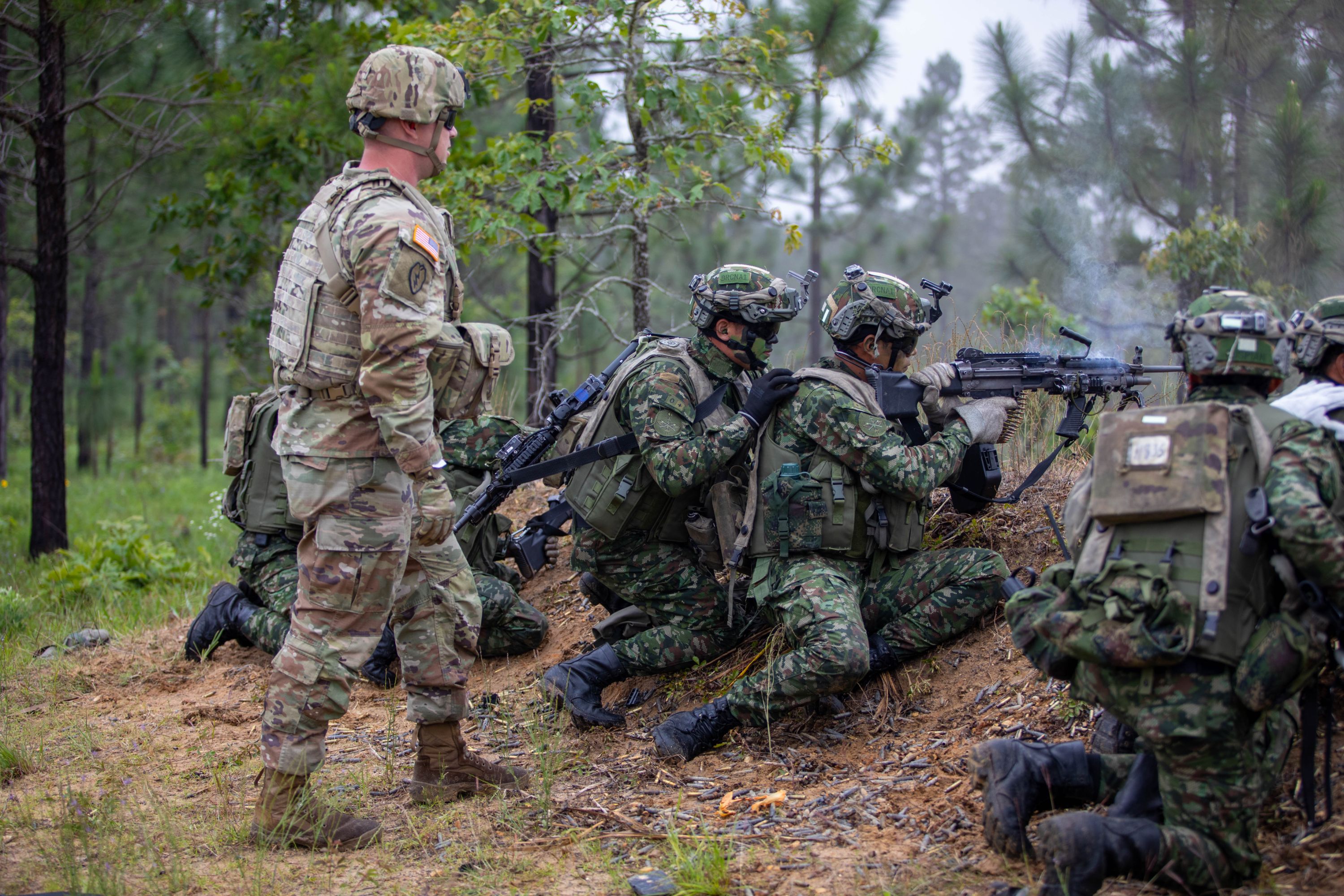 A U.S. Army Soldier observes a group of Colombian and U.S. Soldiers conduct a live fire training lane during their Joint Readiness Training Center rotation at Fort Polk, La. on May 5, 2023. (U.S. Army photo by Sgt. 1st Class Alan Brutus)