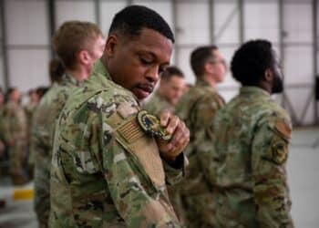 U.S. Air Force Omari Miller, 495th Fighter Generation Squadron F-35 avionics technician, replaces his 748th Aircraft Maintenance Squadron patch with the 495th Fighter Generation Squadron patch, signifying the deactivation and activation of the squadrons at RAF Lakenheath, England, June 9, 2023.