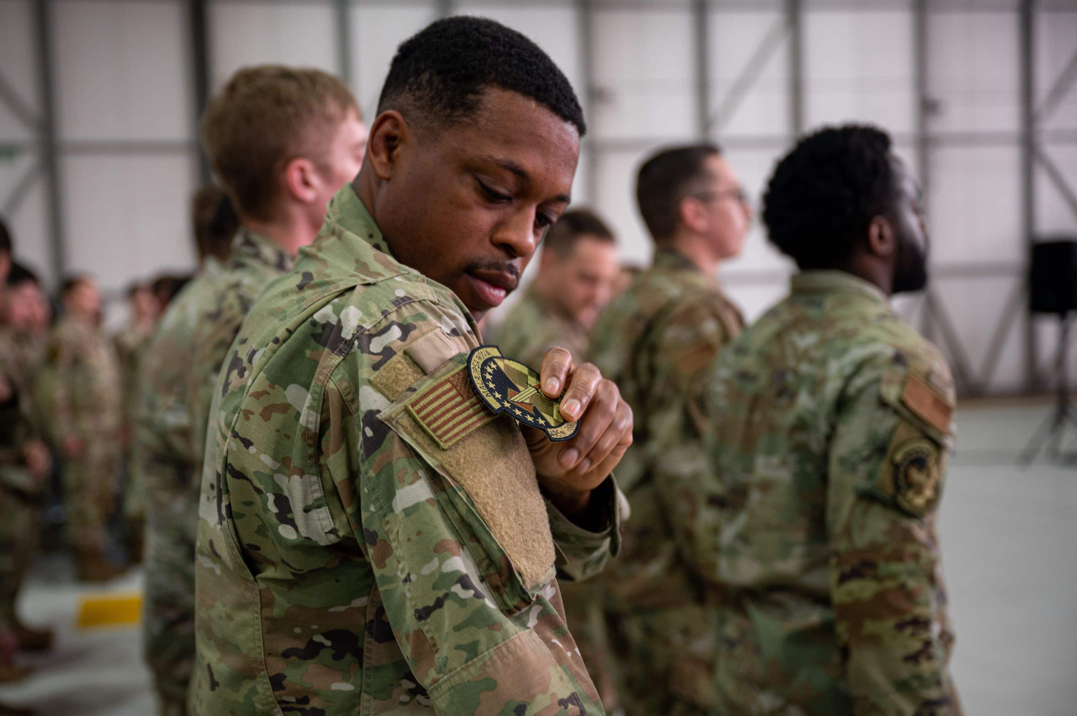U.S. Air Force Omari Miller, 495th Fighter Generation Squadron F-35 avionics technician, replaces his 748th Aircraft Maintenance Squadron patch with the 495th Fighter Generation Squadron patch, signifying the deactivation and activation of the squadrons at RAF Lakenheath, England, June 9, 2023.