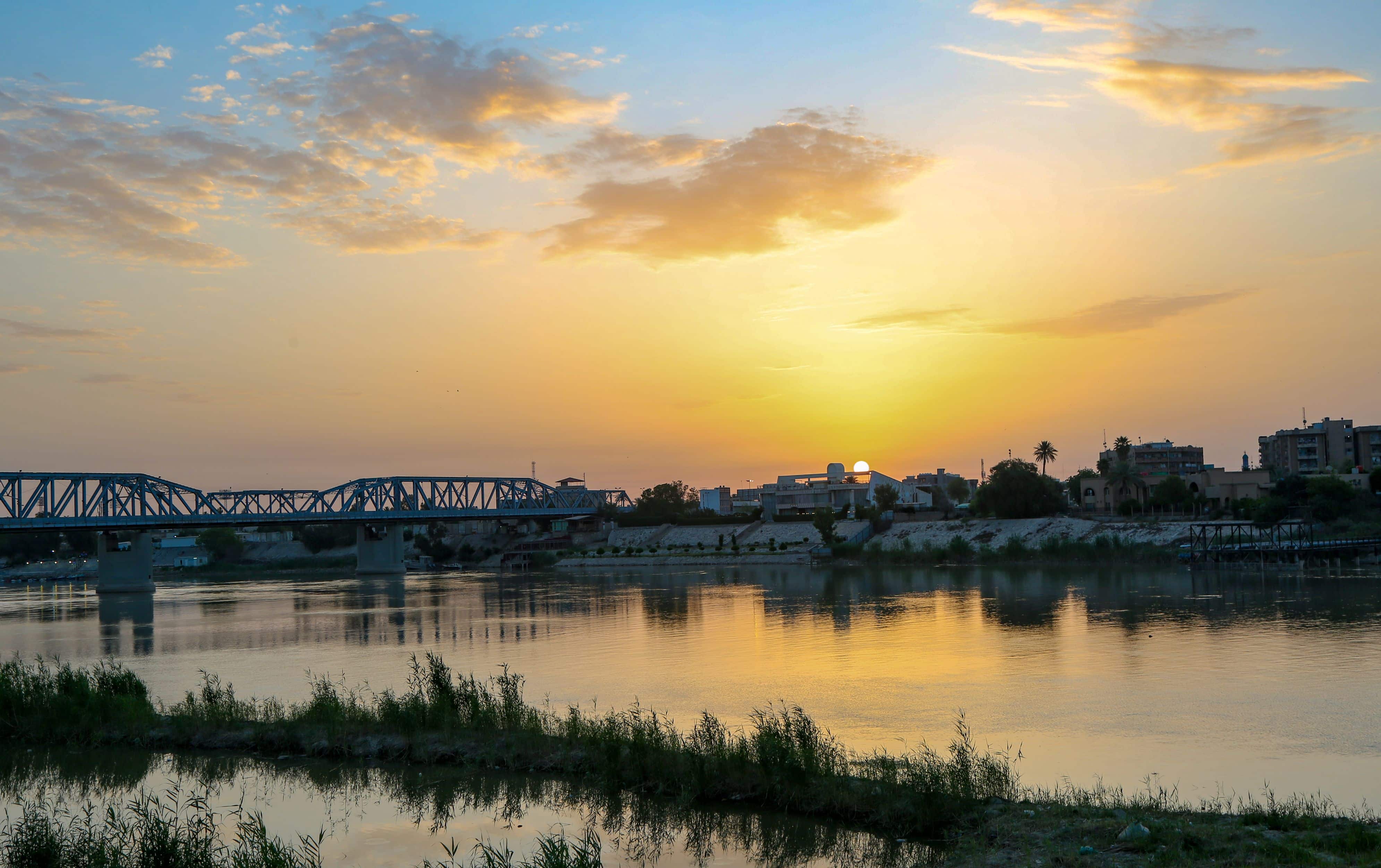 Baghdad, Iraq – April 4, 2020: photo for sunrise in Baghdad city in Iraq, which showing the Sarafia Bridge and Tigris river, and many of buildings.