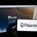 Stuttgart, Germany - 06-05-2021: Person holding smartphone with logo of US software company Palantir Technologies Inc. on screen in front of website. Focus on phone display. Unmodified photo.