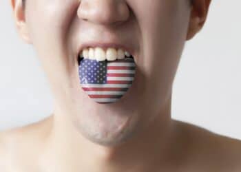 USA or United States flag painted in tongue of a man - indicating English language and American accent speaking, study in America concept