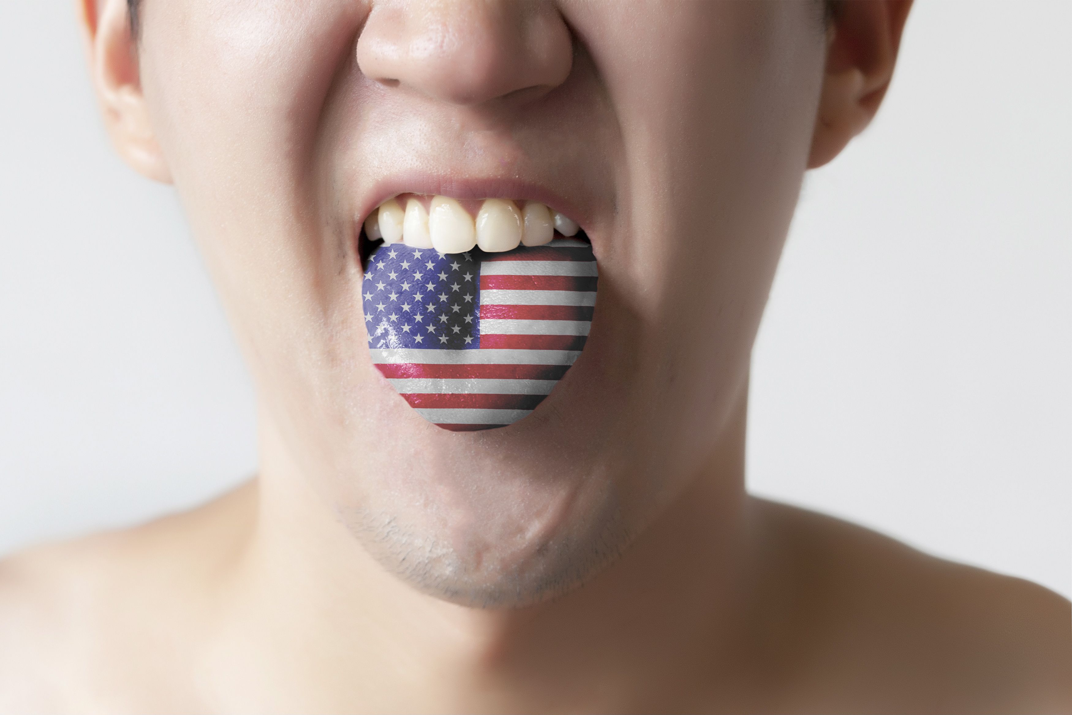 USA or United States flag painted in tongue of a man - indicating English language and American accent speaking, study in America concept