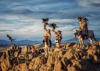 Mongolian eagle Hunters in traditionally wearing typical Mongolian Fox dress culture of Mongolia on Altai Mountain background at Ba-yan UiGII, MONGOLIA