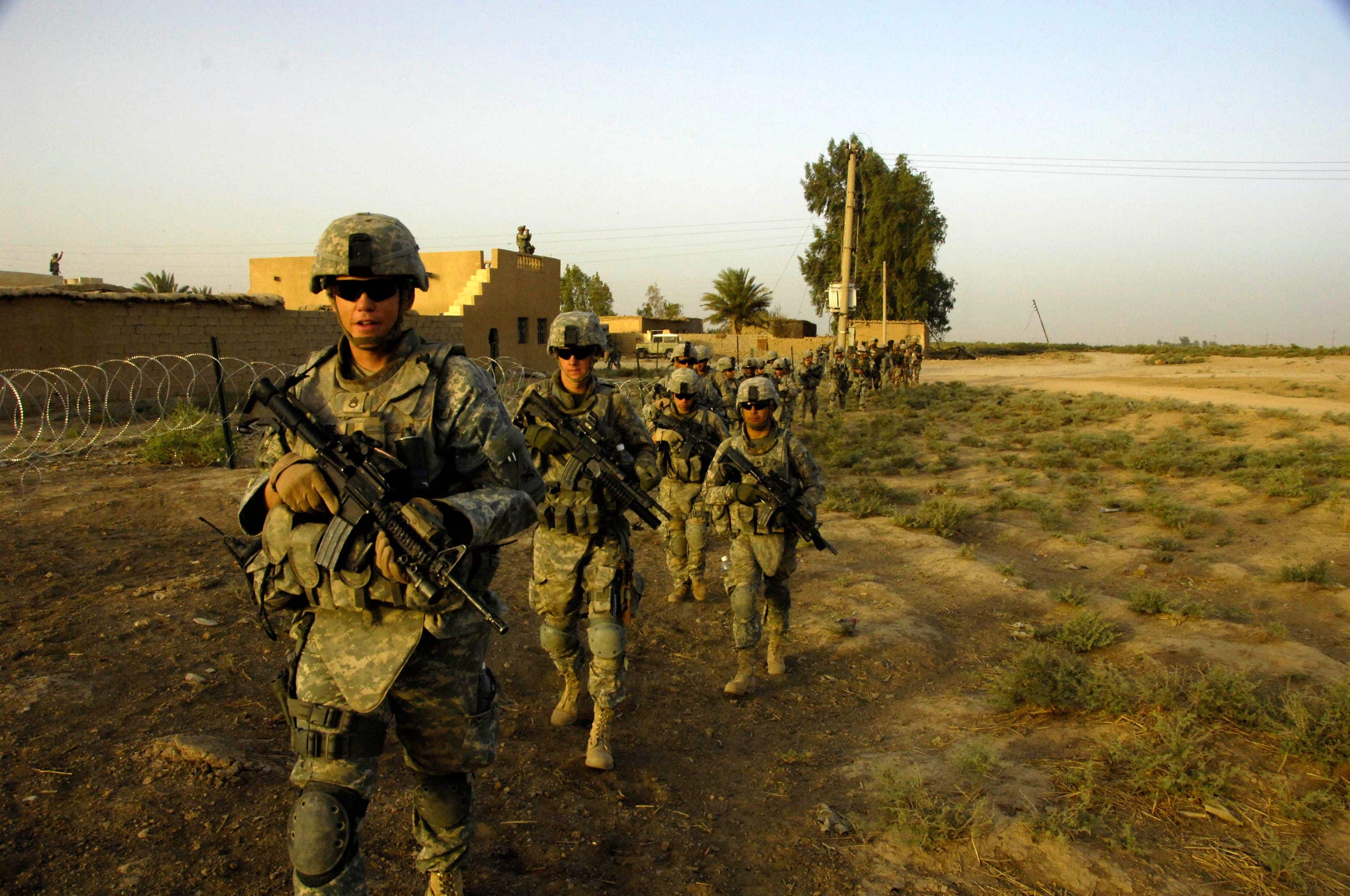 U.S. Army Soldiers from 1st Platoon, G Troop, Task Force 1-35, 2nd Brigade Combat Team move out on patrol in search of weapons cache with an attachment of Iraqi army Soldiers during Operation Iron Pursuit on July 28, 2008 in 7 Nissan village, Diyala province, Iraq.