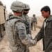 U.S. Army 1st Lt. Lorenzo Ruiz, Platoon Leader, 2nd Platoon, Bravo Company, 1st Brigade, 37th Battalion, 1st Brigade Combat Team, 1st Armored Division, from Edinburg, Texas, shakes hands with a young famer during an Indirect Fire Patrol near Al-Mustafia, Iraq, Feb. 23. U.S. Soldiers conduct IDFs to find evidence of mortar launch sites or attacks against military instillations.