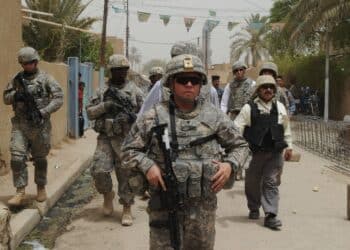 U.S. Soldiers assigned to Bravo Company,1st Battalion, 10th Field Artillery Regiment, 3rd Heavy Brigade Combat Team, 3rd Infantry Division along with U.S. Dr. Ike Khan, from Chicago, Provincial Reconstruction Team member, walk to a building under construction in Wasit province, Iraq, July 22. U.S. forces assisted Iraqi forces in building,renovation, and Humanitarian Aid in support of Operation Iraqi Freedom.