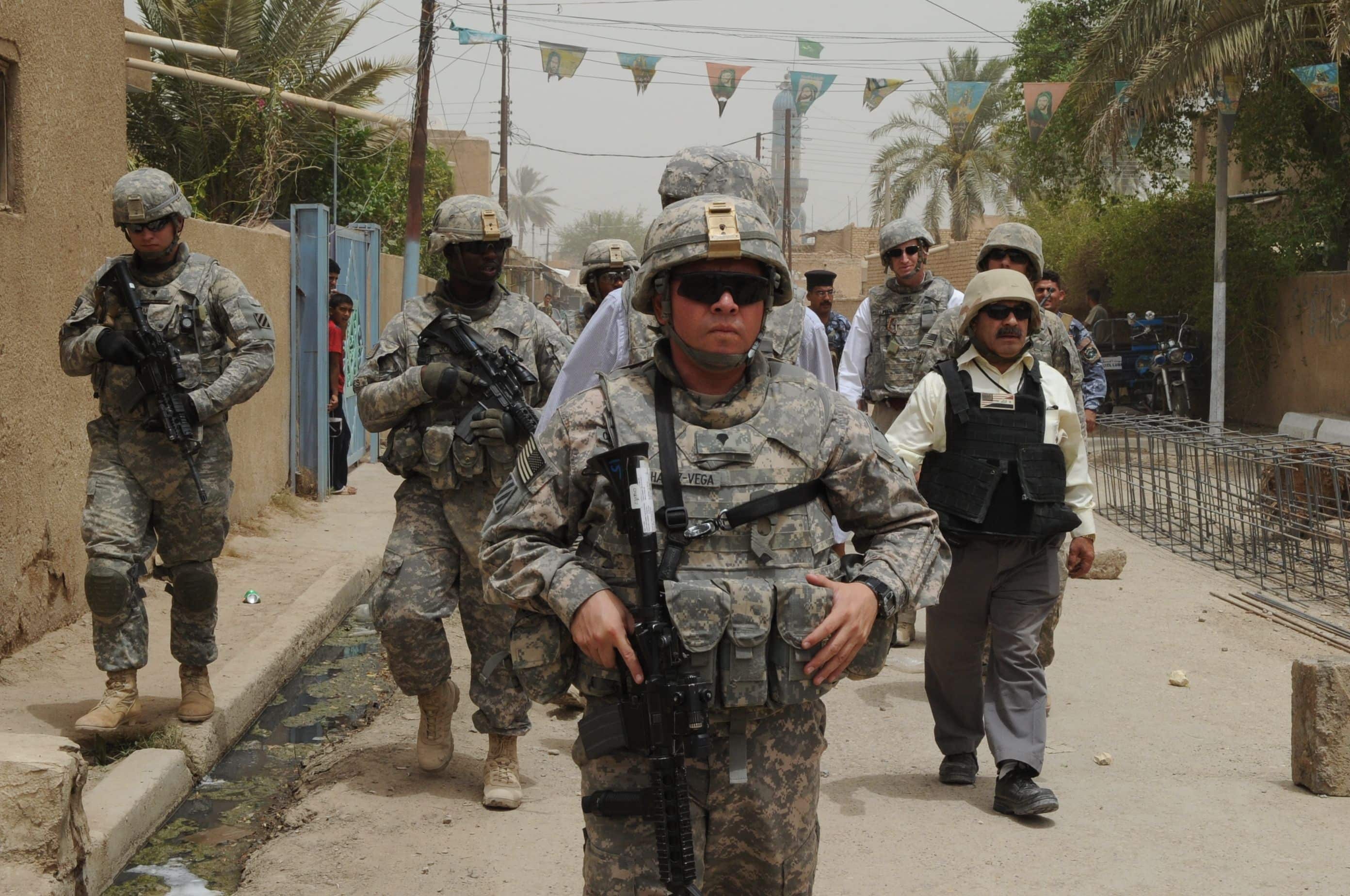 U.S. Soldiers assigned to Bravo Company,1st Battalion, 10th Field Artillery Regiment, 3rd Heavy Brigade Combat Team, 3rd Infantry Division along with U.S. Dr. Ike Khan, from Chicago, Provincial Reconstruction Team member, walk to a building under construction in Wasit province, Iraq, July 22. U.S. forces assisted Iraqi forces in building,renovation, and Humanitarian Aid in support of Operation Iraqi Freedom.