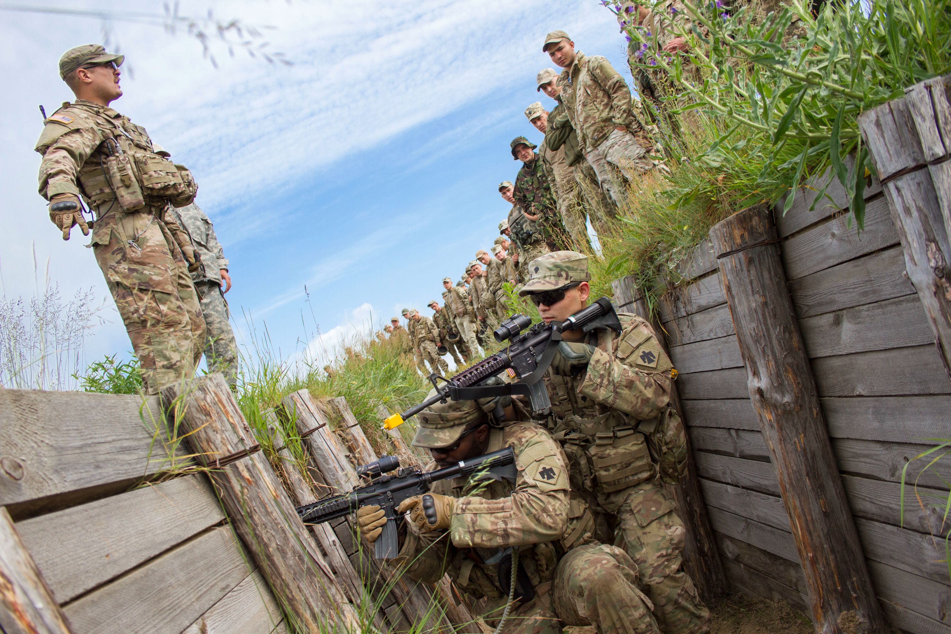 Sgt. Brett Mussyal, a U.S. Army Soldier with the 45th Infantry Brigade Combat Team, explains how to clear a trench to Ukrainian soldiers from the 1st Airmobile Battalion, 79th Air Assault Brigade while U.S. Soldiers demonstrate during trench assault and clearance training at the Yavoriv Combat Training Center on the International Peacekeeping and Security Center, near Yavoriv, Ukraine, on June 13.