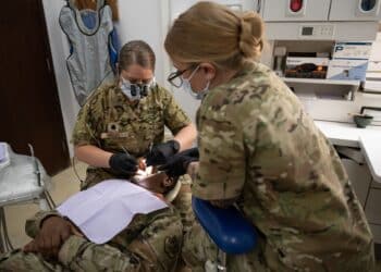 U.S. Air Force Lt. Col. Paula Morse, chief of dental services, 386th Expeditionary Medical Group, performs a dental examination on Capt. Koech C. Bellion, public health officer, 386th EMDG, while Tech. Sgt. Shannon Raaymakers, noncommissioned officer in charge of dental services, 386th EMDG