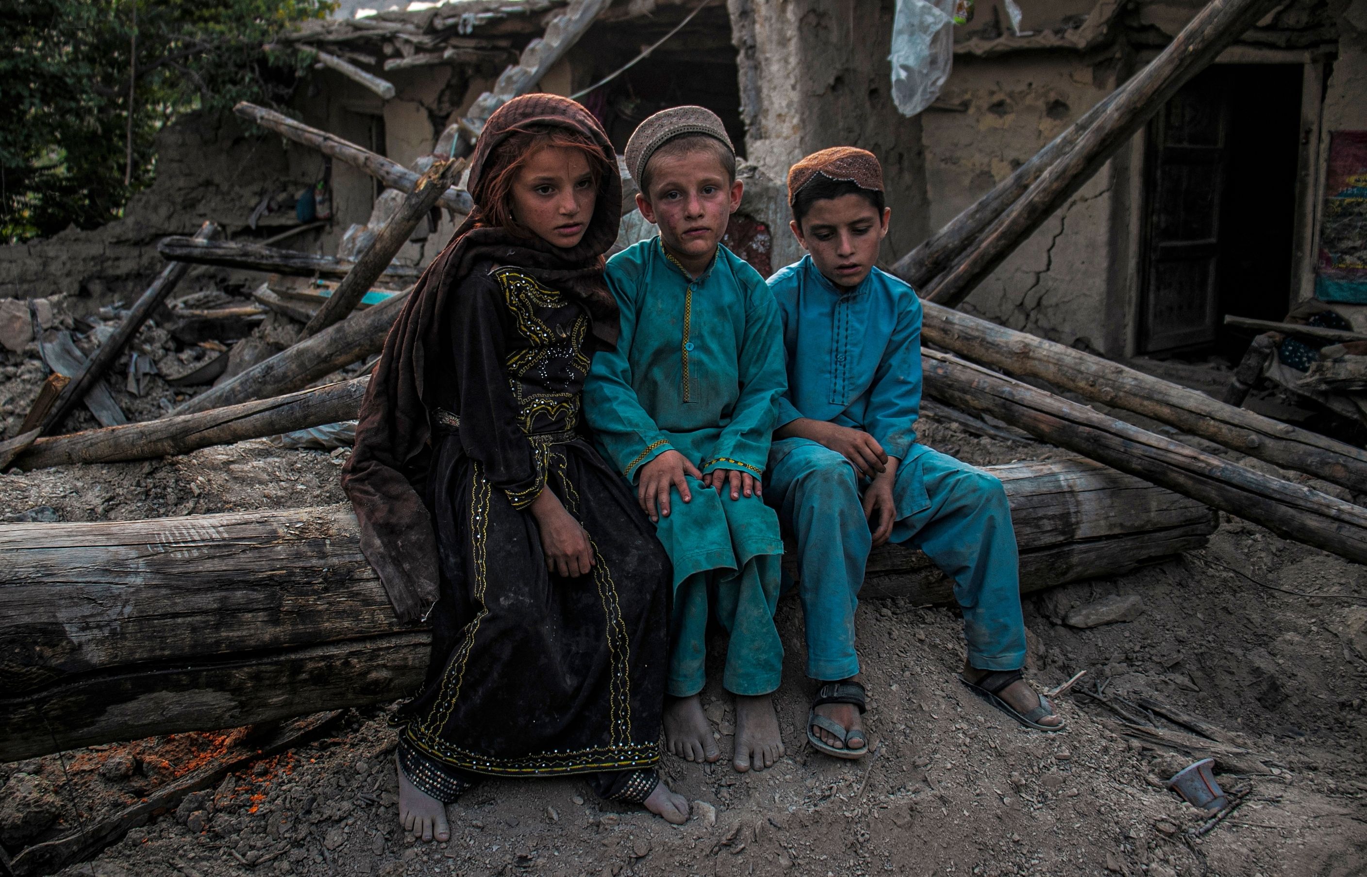 Poor and needy Afghan children sitting on the ground after an earthquake - Paktika, Afghanistan August 4, 2022