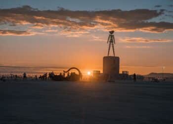 Nevada, United States. September 10, 2022. Beautiful desert with art objects at sunrise. Beautiful nature Burning Man festival with people riding bicycles.