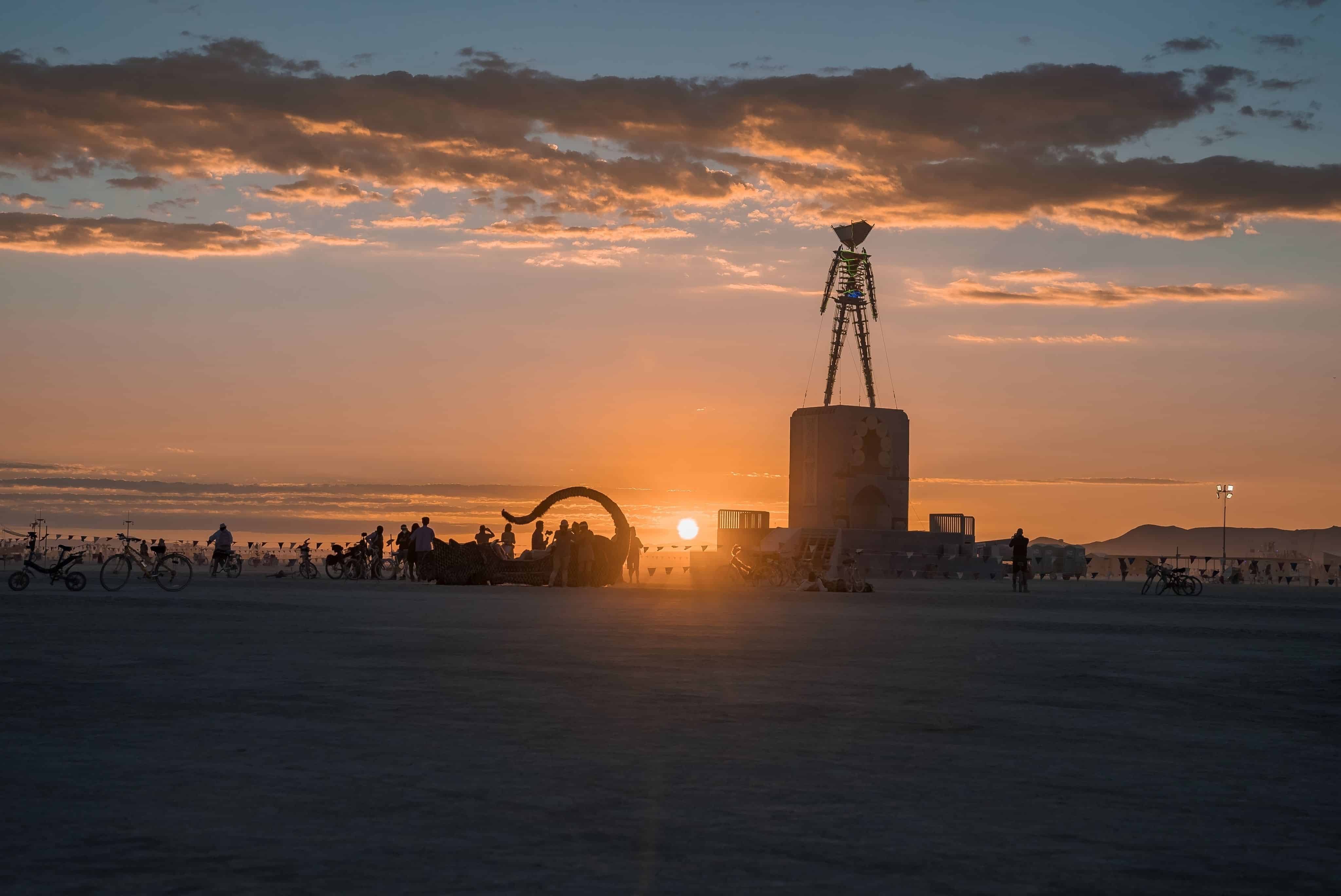 Nevada, United States. September 10, 2022. Beautiful desert with art objects at sunrise. Beautiful nature Burning Man festival with people riding bicycles.