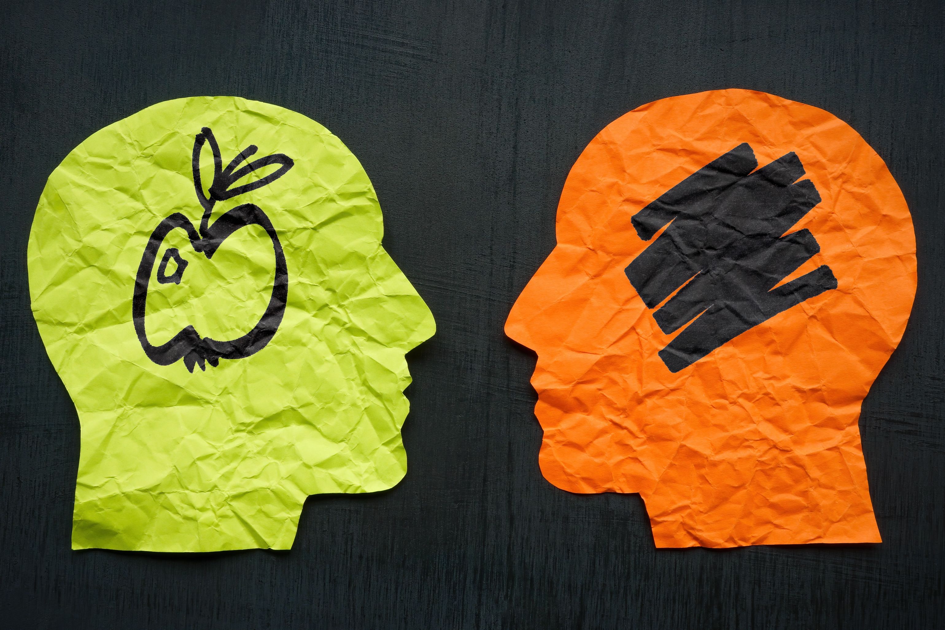 Two paper heads and one with apple. Aphantasia concept.