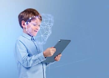 Smiling child boy with tablet in hands, portrait profile with biometric verification hologram and facial recognition. Concept of face id and artificial intelligence
