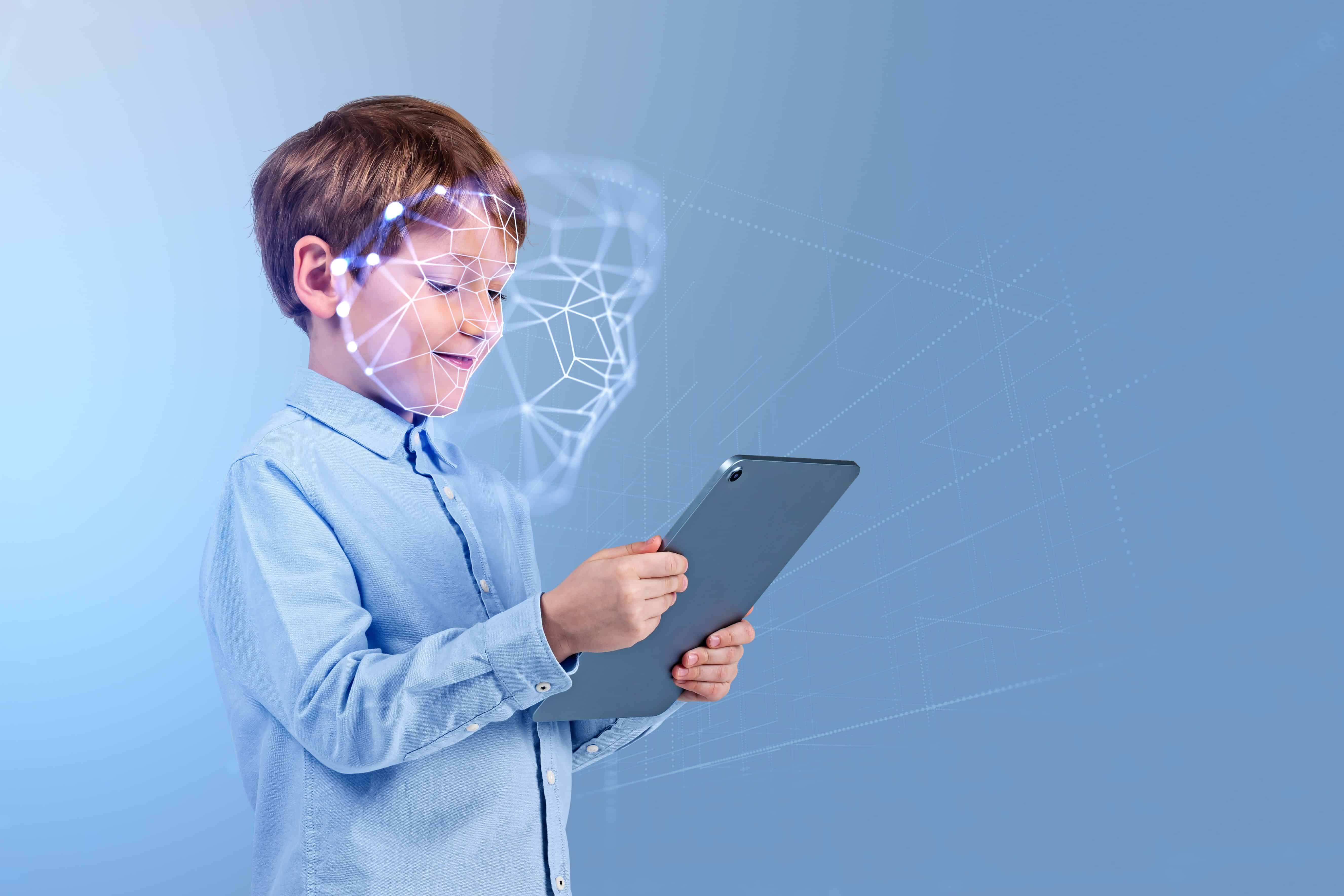 Smiling child boy with tablet in hands, portrait profile with biometric verification hologram and facial recognition. Concept of face id and artificial intelligence
