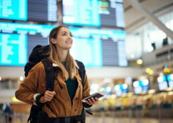 Travel, airport and excited woman with passport. travel ticket and documents for immigration, journey and flight schedule. Backpack person with identity document search for international registration