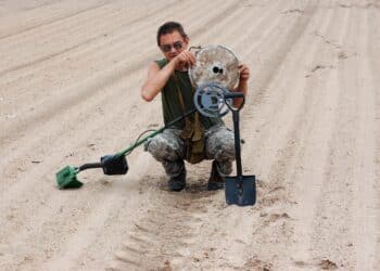 Kiev,Ukraine.June 3.Military archeology. Man with metal detector and German WWII anti tank landmine.Empty mine body,no explosives inside. At June 3,2012 in Kiev, Ukraine